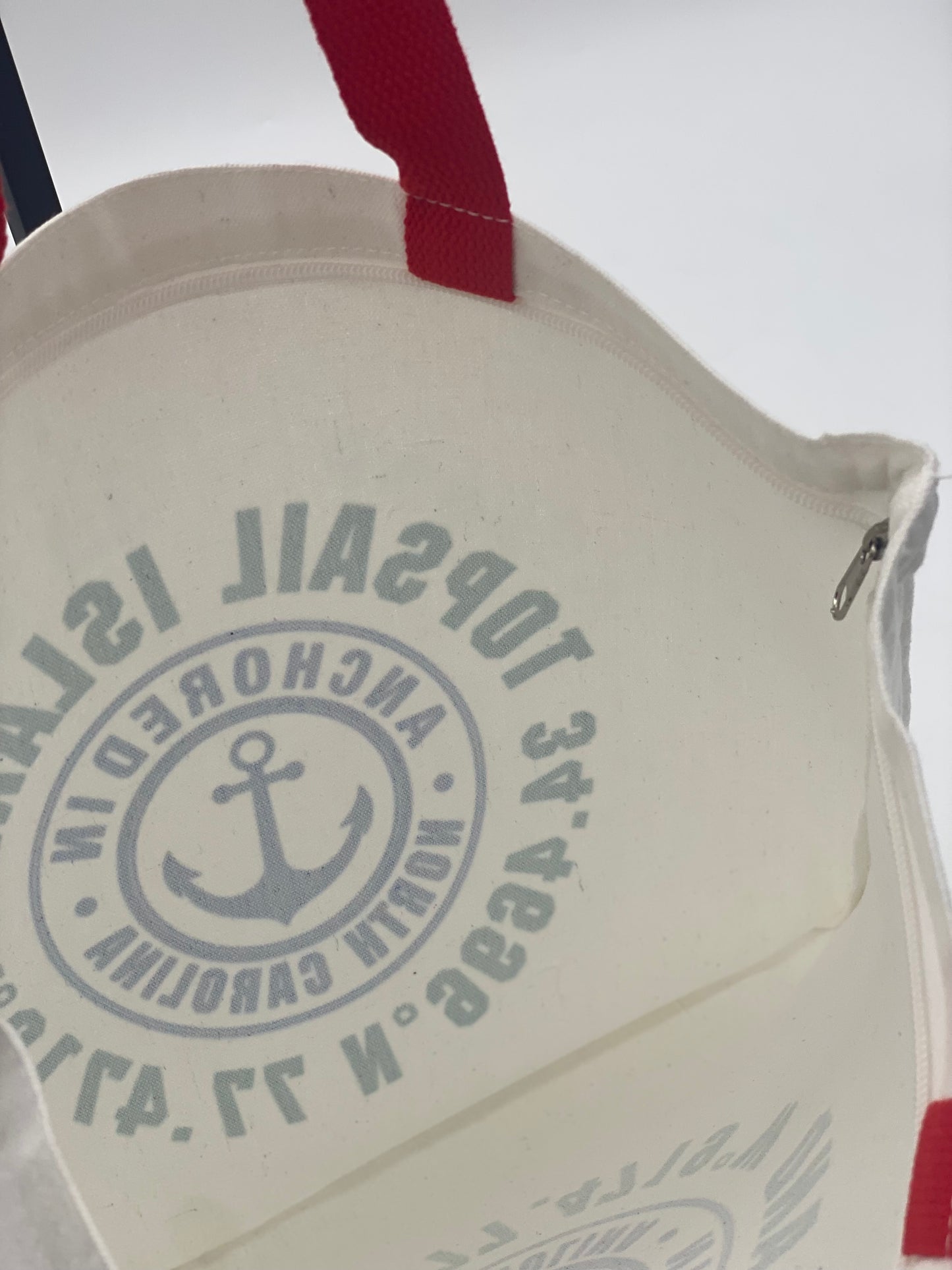 Close-up of the inside a white bag with red handle.