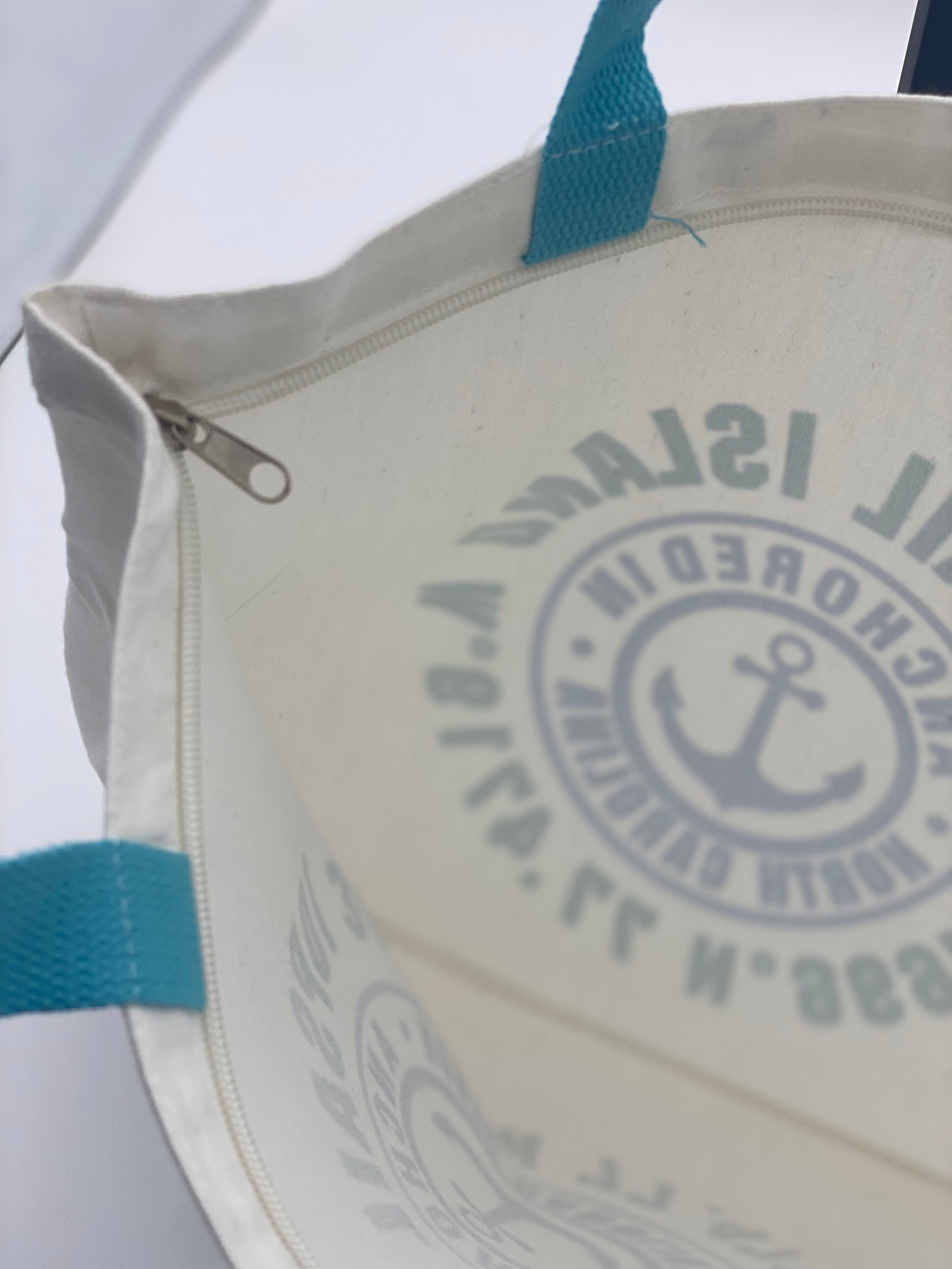 Inside view of white bag with topsail island design and blue handles.