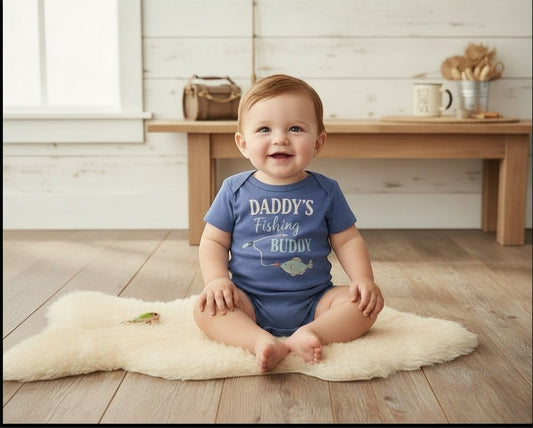 Seaside Custom Apparel & Gifts baby onesie in blue with Daddy's Fishing Buddy print on a soft sheepskin rug