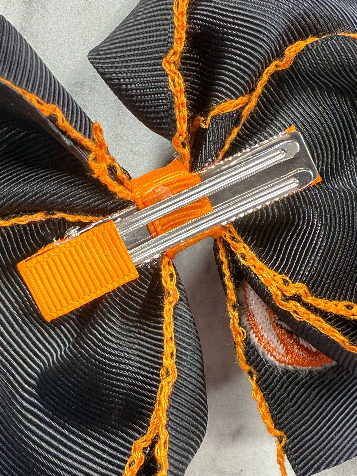 Seaside Custom Apparel & Gifts black hair bow with orange moonstitch embroidery and a secure metal alligator clip