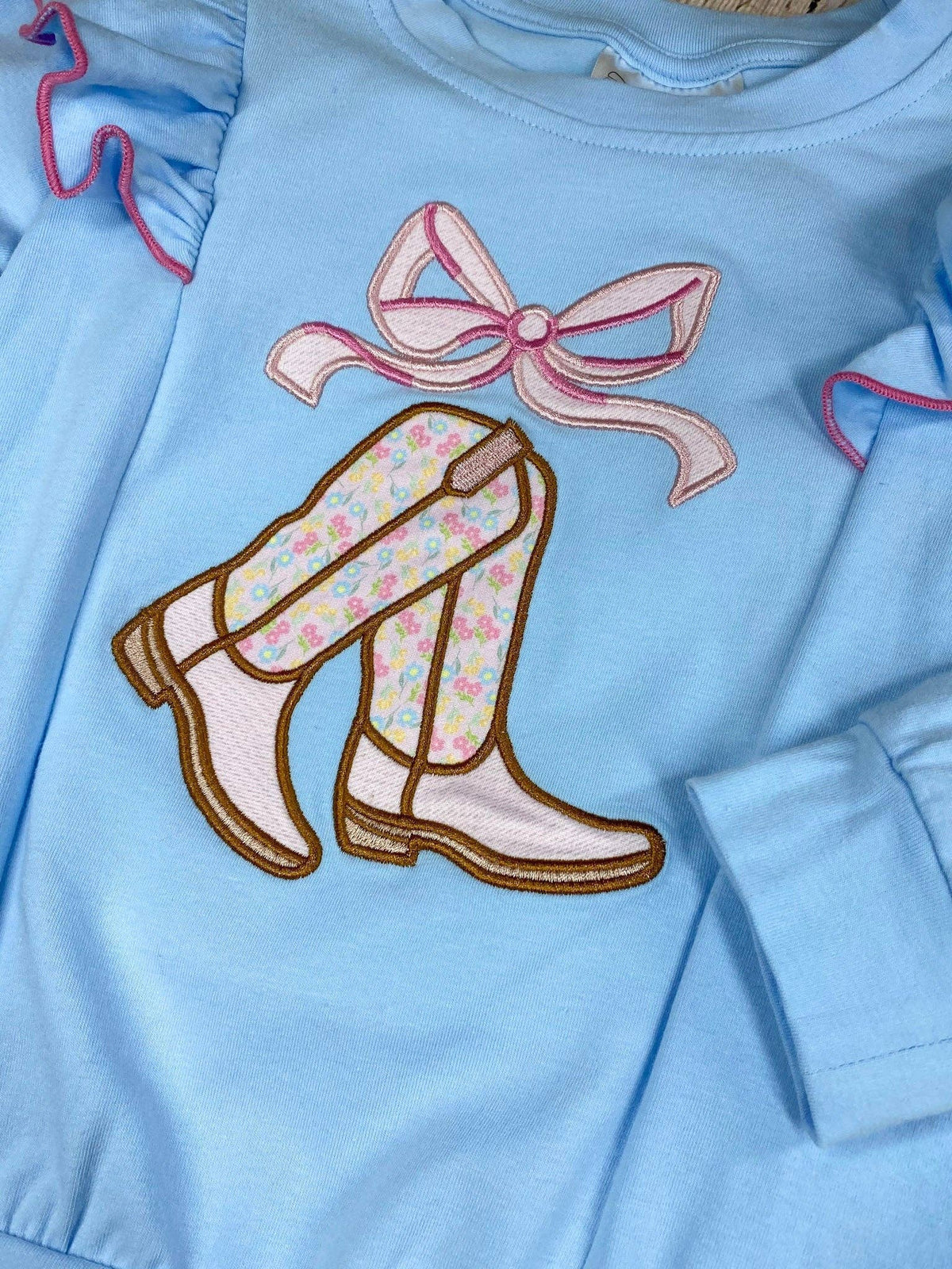 Seaside Custom Apparel & Gifts light blue long sleeve top with flutter shoulders and embroidered cowgirl boots and bow