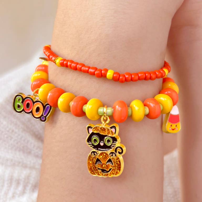 Seaside Custom Apparel & Gifts Halloween beaded bracelet with candy corn, black cat, and BOO charms on a child's wrist