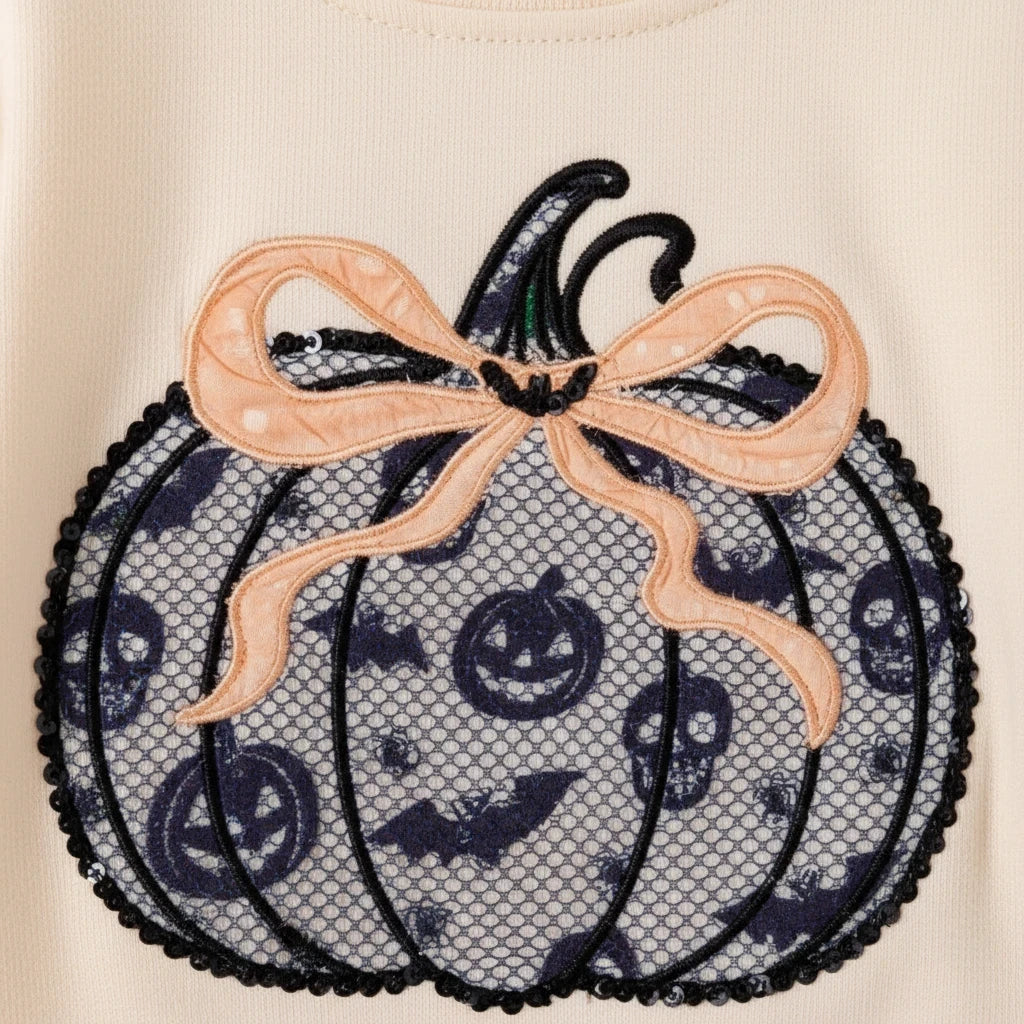 Seaside Custom Apparel & Gifts pumpkin appliqué with lace overlay, skull and bat print, and peach bow on cream fabric