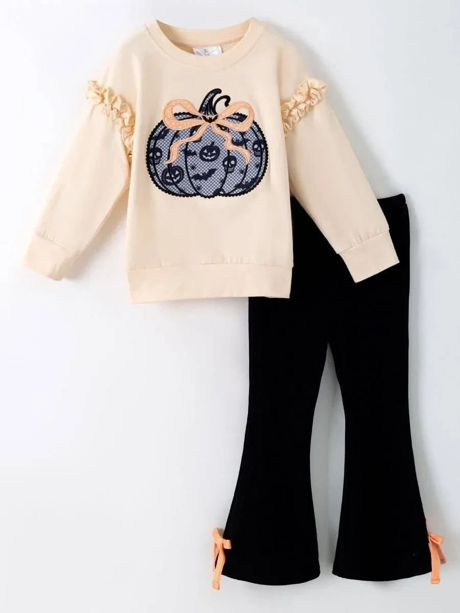 Seaside Custom Apparel & Gifts girls fall outfit with cream ruffle top, pumpkin appliqué, and black bell bottoms.