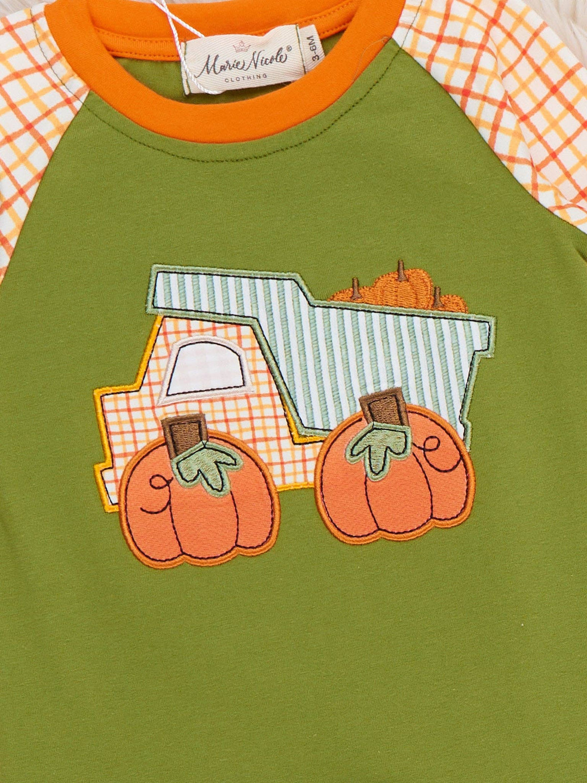 Seaside Custom Apparel & Gifts baby romper with pumpkin dump truck embroidery, green body, and orange plaid sleeves.