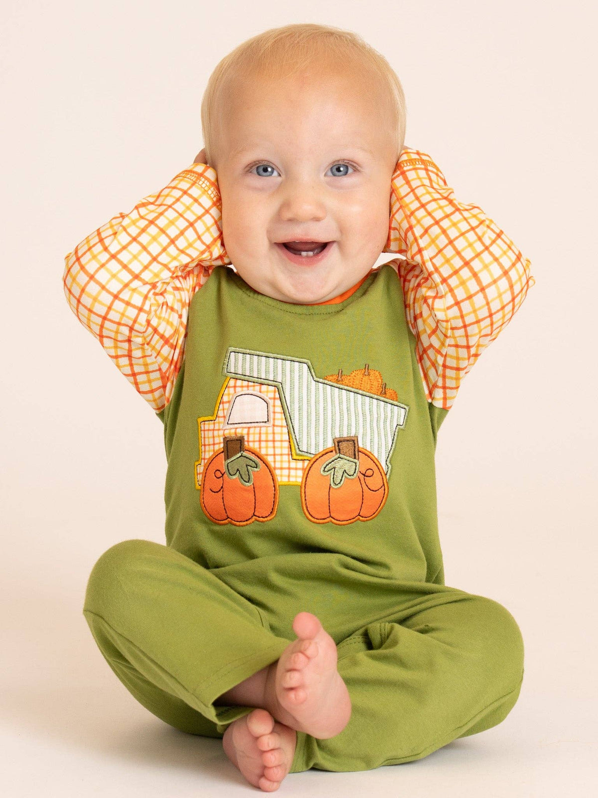 Seaside Custom Apparel & Gifts baby romper with pumpkin dump truck embroidery and orange plaid sleeves on a baby boy