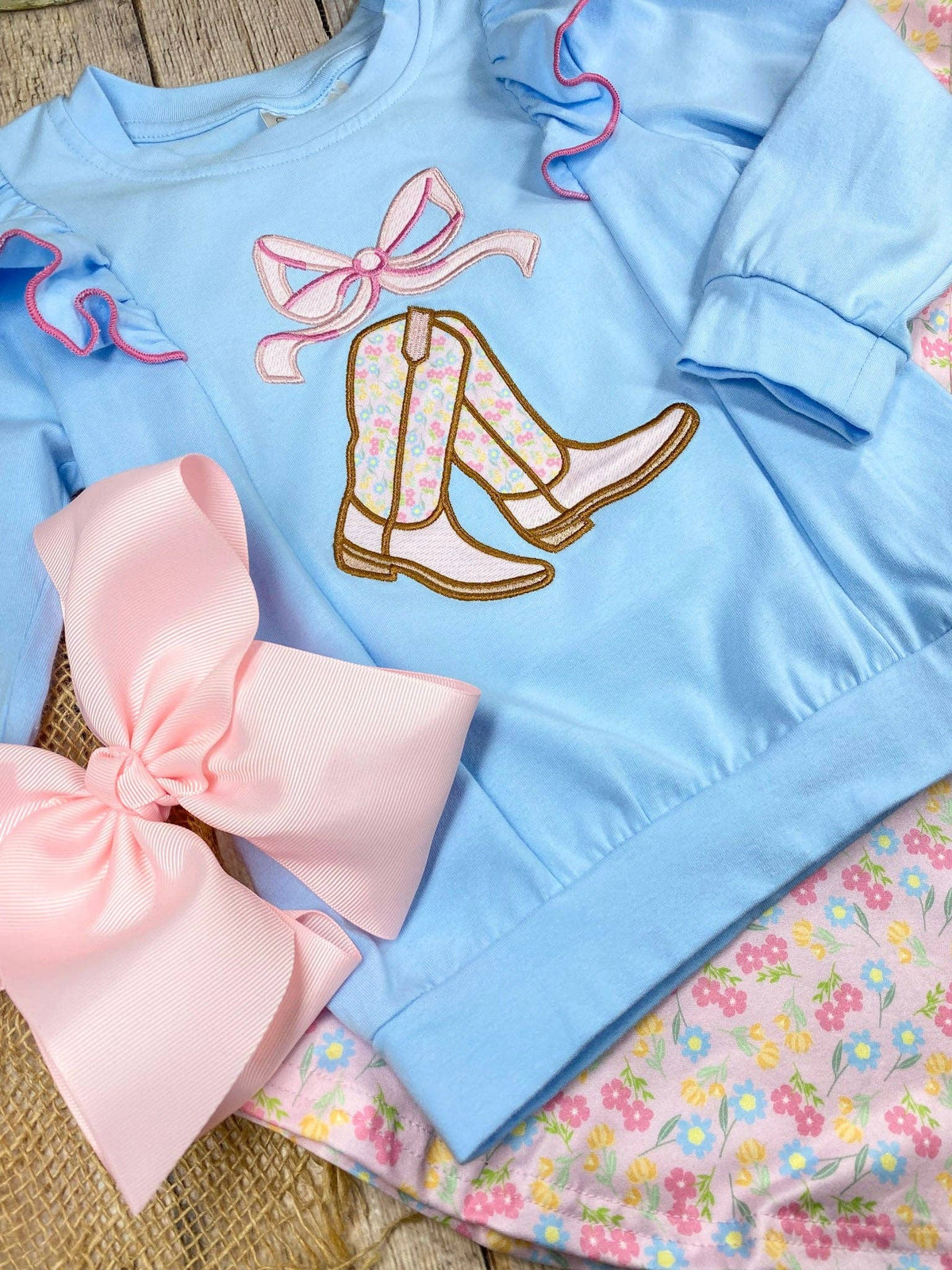 Seaside Custom Apparel & Gifts girls western outfit with blue flutter sleeve top, cowgirl boot embroidery, and bow.