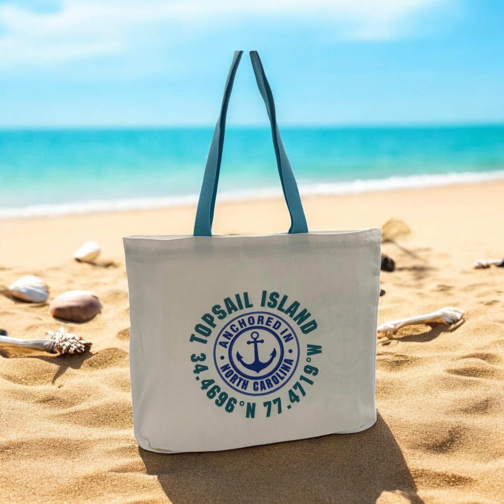 Tote bag with 'TopSail Island' cordinates design on a sandy beach with ocean view